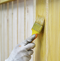 Fence being treated with stain and sealant.