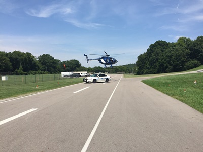 Helicopter hovering above road behind police car