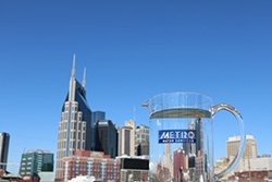 Clear pitcher of Nashville water in front of Nashville downtown skyline