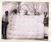 People showing off mattress they constructed.